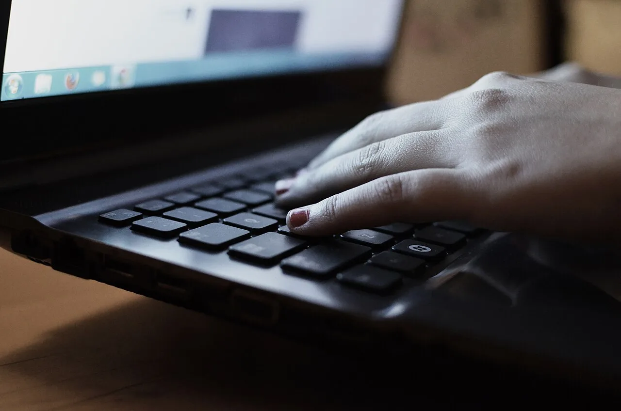 Primo piano di una mano che scrive sulla tastiera di un portatile