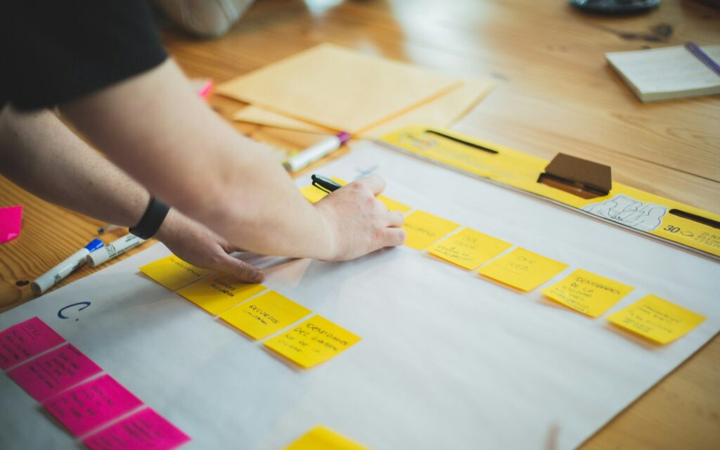 Mani che organizzano post-it colorati per pianificare una campagna di marketing